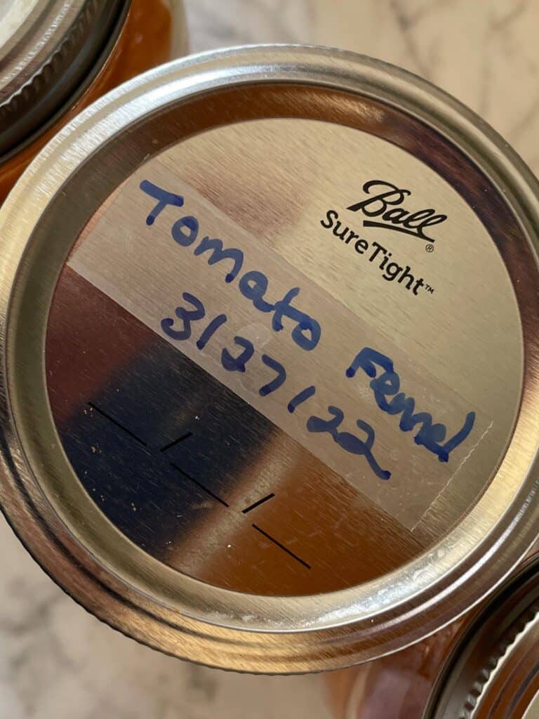 Top of Mason Jar with Tomato Fennel soup scotch tape label written in blue sharpie ink
