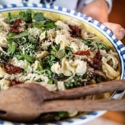 Serving Bowl of Orecchiette Pasta with Broccolini, Sun-dried Tomatoes and garnished with basil and parmesean