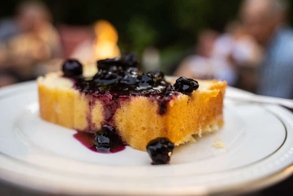 Blueberry jam on a lemon pound cake on a white plate