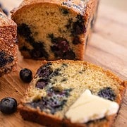2 loaves of blueberry lemon yogurt cake on a cutting board
