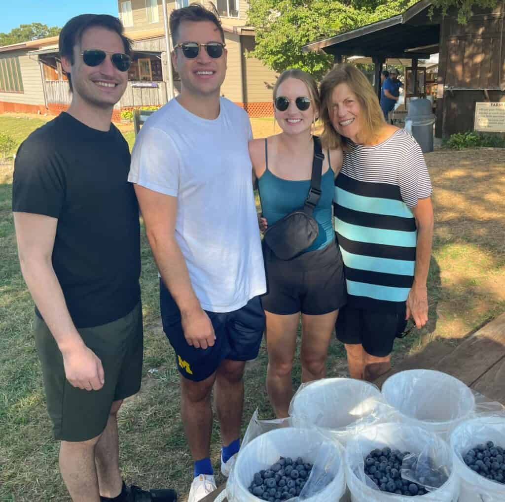 family with buckets of freshly picked blueberries
