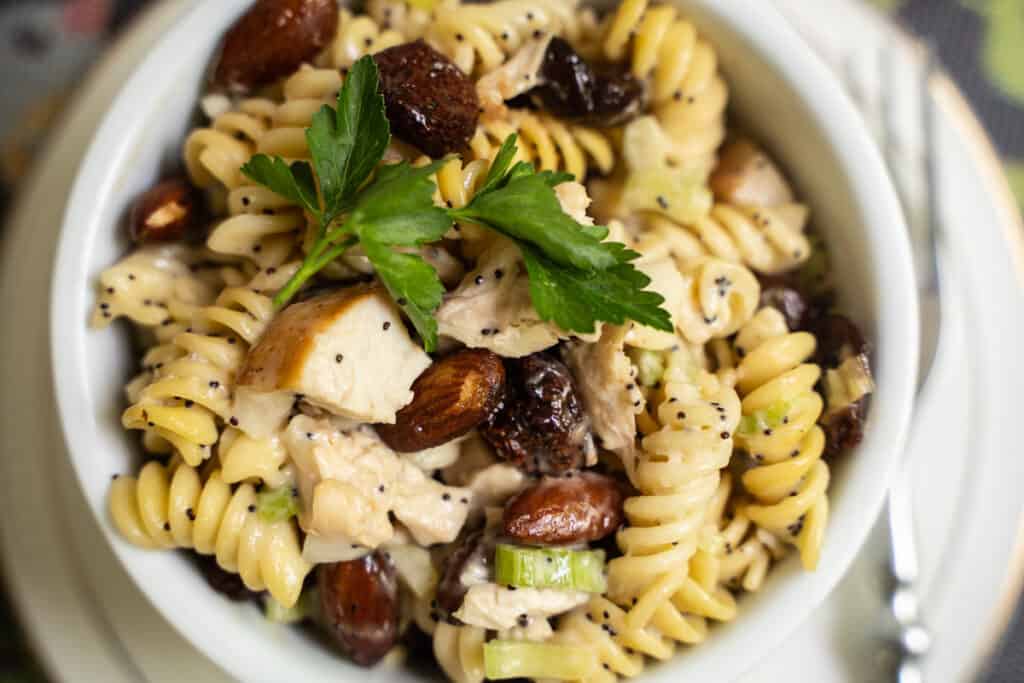 Chicken Salad with rotini pasta, dried cherries, whole almonds in a poppy seed dressing in a ramekin