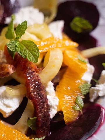 Roasted Beet Salad For TWo on a white plate with oranges, fennel, goat cheese and a mint vinegar dressing