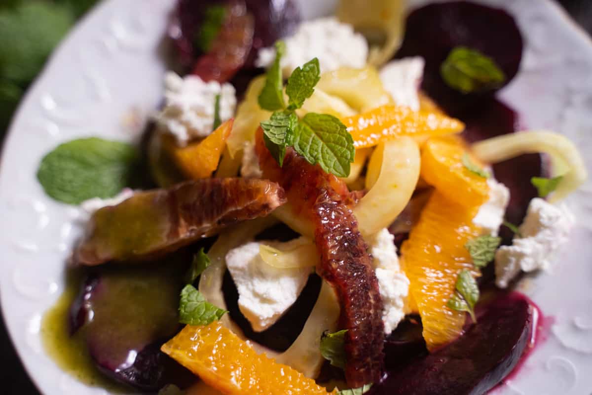Roasted Beet Salad For TWo on a white plate with oranges, fennel, goat cheese and a mint vinegar dressing
