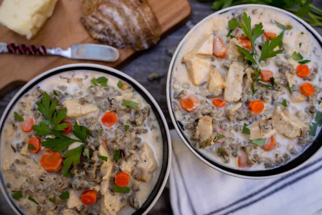 Leftover Turkey Wild Rice Soup in a bowl alongside bread on a cutting board