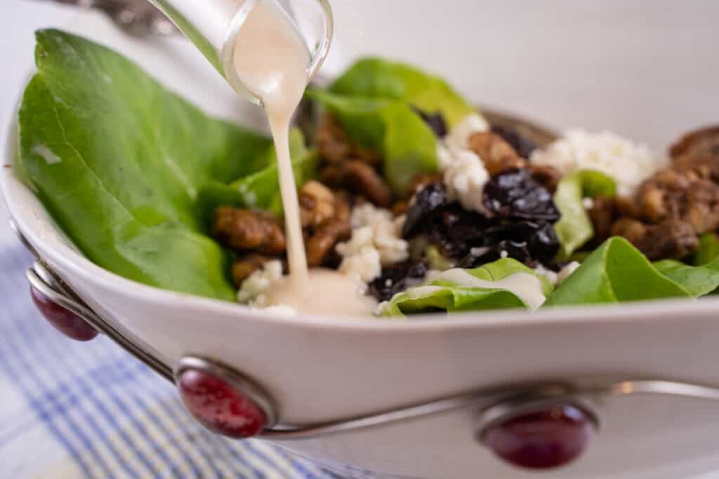 our favorite shallot vinaigrette perfect for two being drizzled on a simple green salad