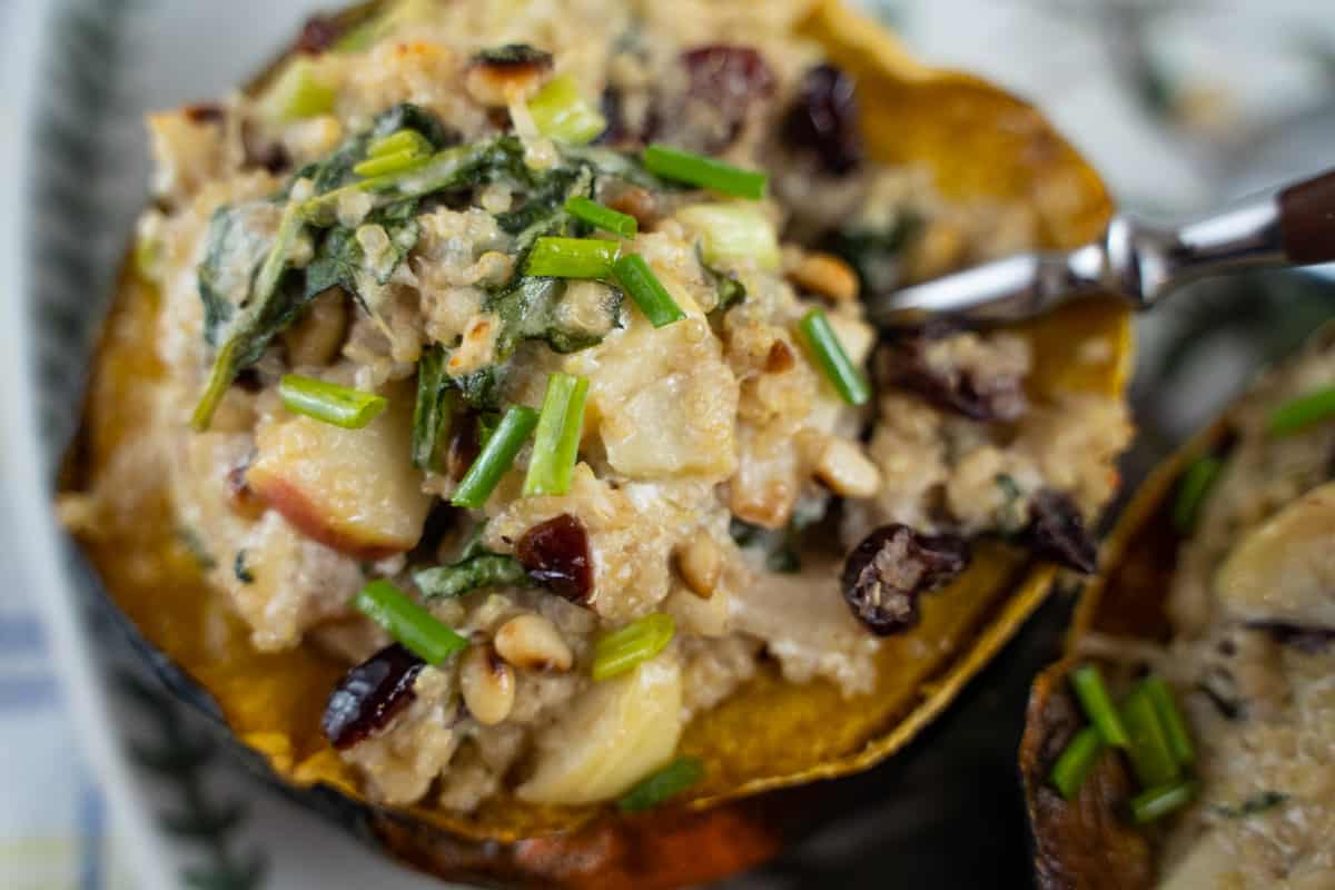 Quinoa stuffed acorn squash with leeks, apples, goat cheese, pine nuts. Garnished with chives