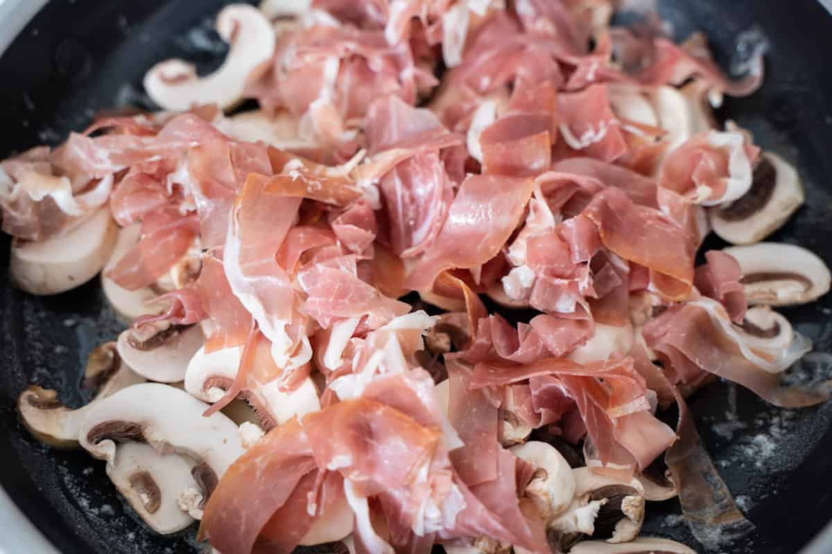 prosciutto and mushrooms in a skillet