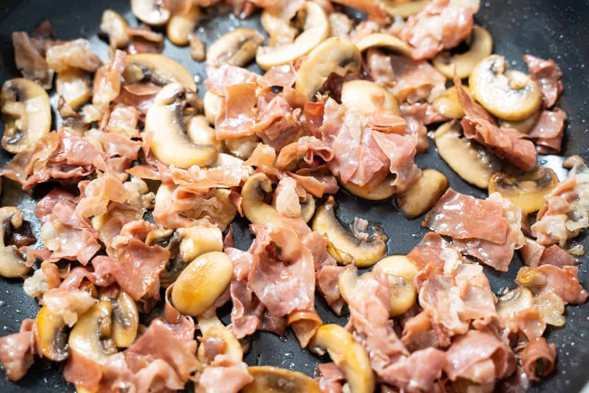 Perfectly crisped prosciutto and browned mushrooms in a skillet