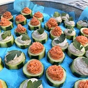 cucumber canapes two ways, sun-dried tomato mousse and smoked salmon on a blue tray