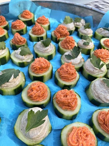 cucumber canapes two ways, sun-dried tomato mousse and smoked salmon on a blue tray