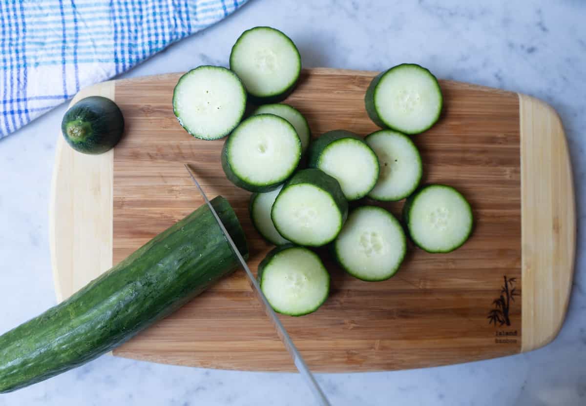Cucumbers sliced in thin slices on a cutting board
