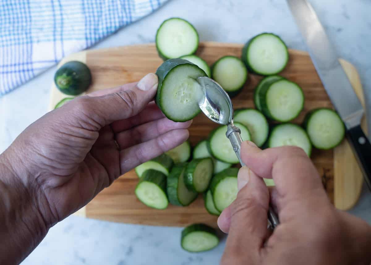 scooping a well out of the center of a cucumber slice