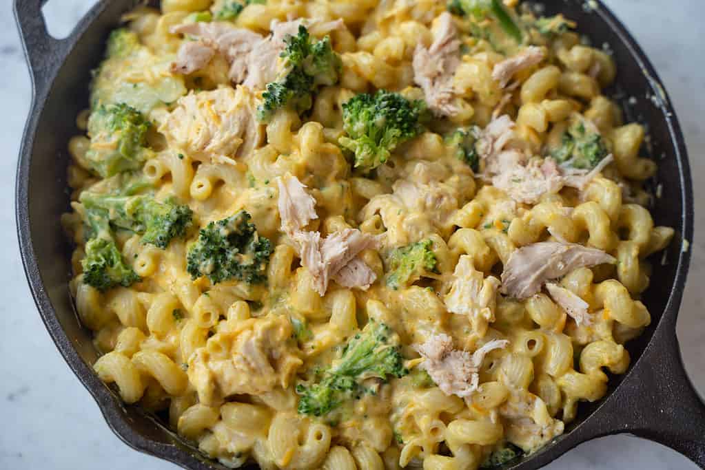 Ingredients for a Chicken Broccoli Pasta Casserole in a cast iron skillet