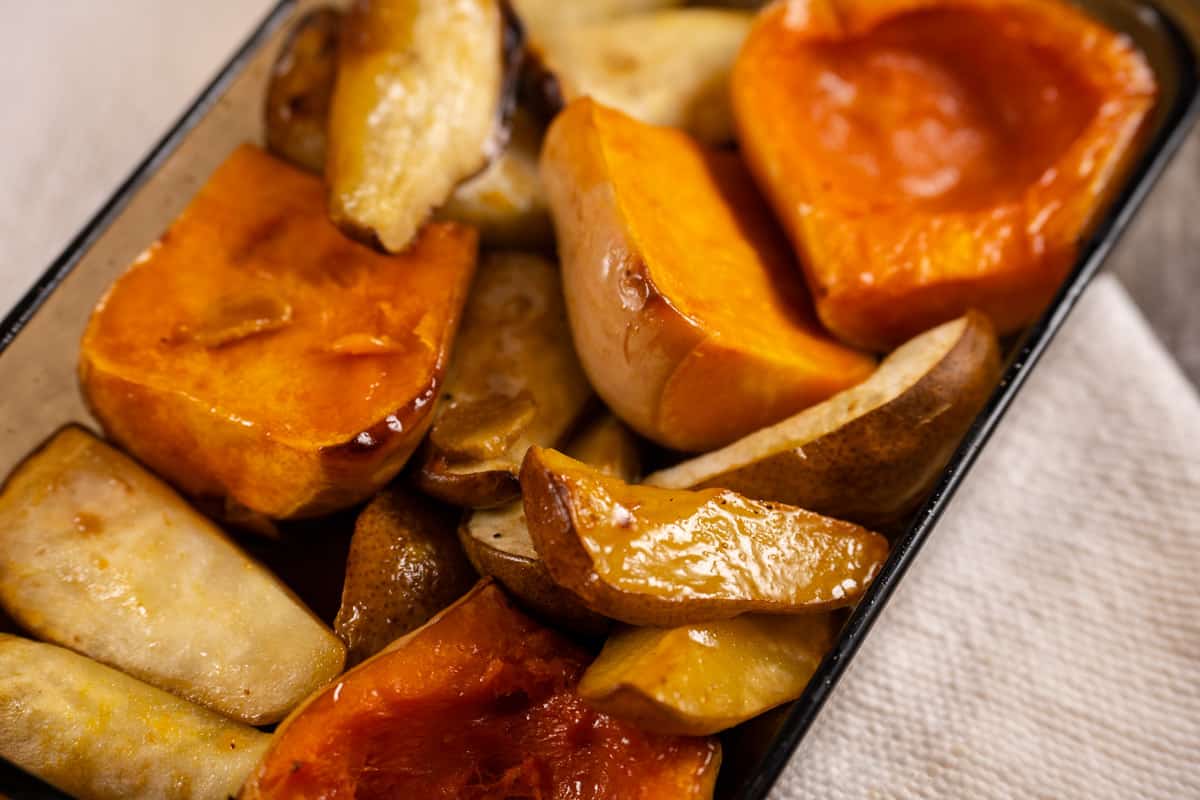 Roasted butternut squash, pear and ginger for soup in a baking dish.