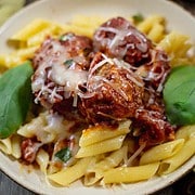 Sicilian Meatballs for Two on a bed of pasta served on a tan plate