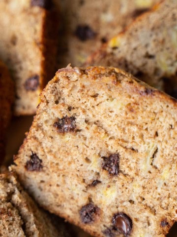 Sliced banana bread with applesauce on a tray.