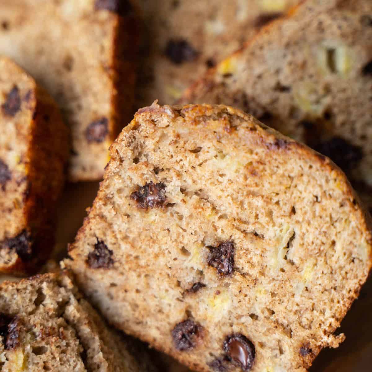 Sliced banana bread with applesauce on a tray.