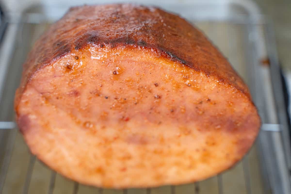 baked glazed ham on baking sheet
