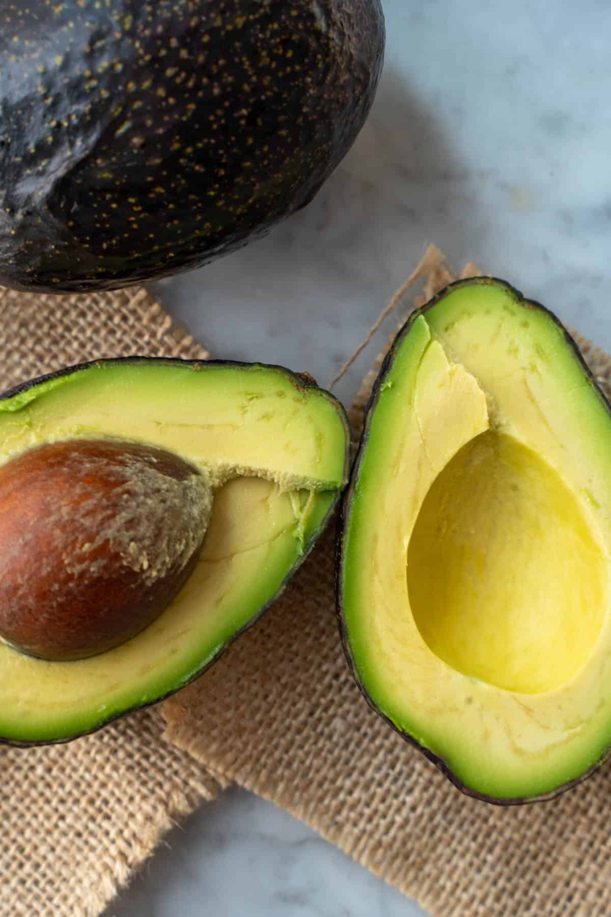 a avocado sliced open with the pit in one half