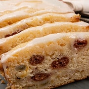glazed lemon cake loaf sliced sitting next to 2 plates and forks