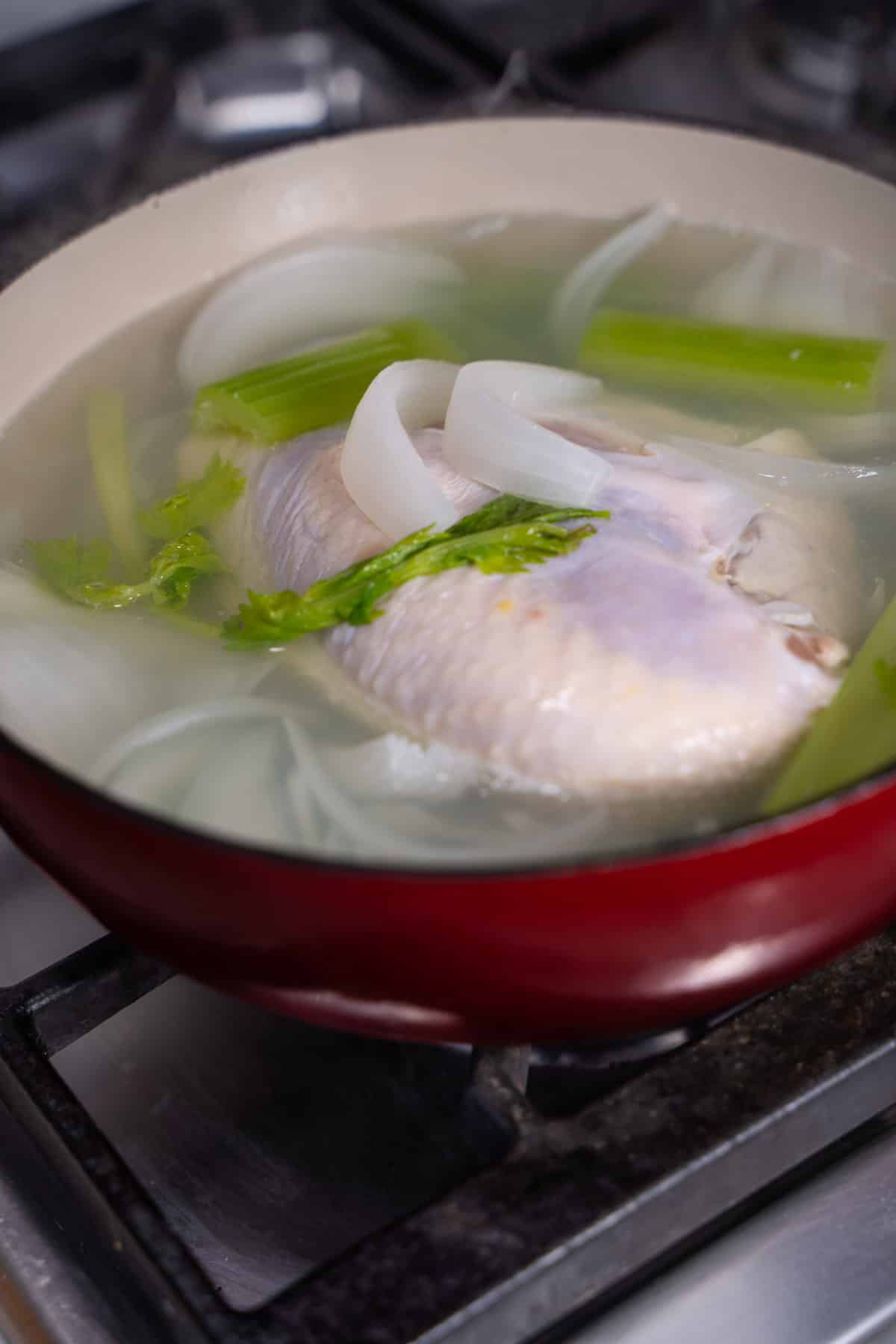 chicken, onion and celery in a stock pot simmering