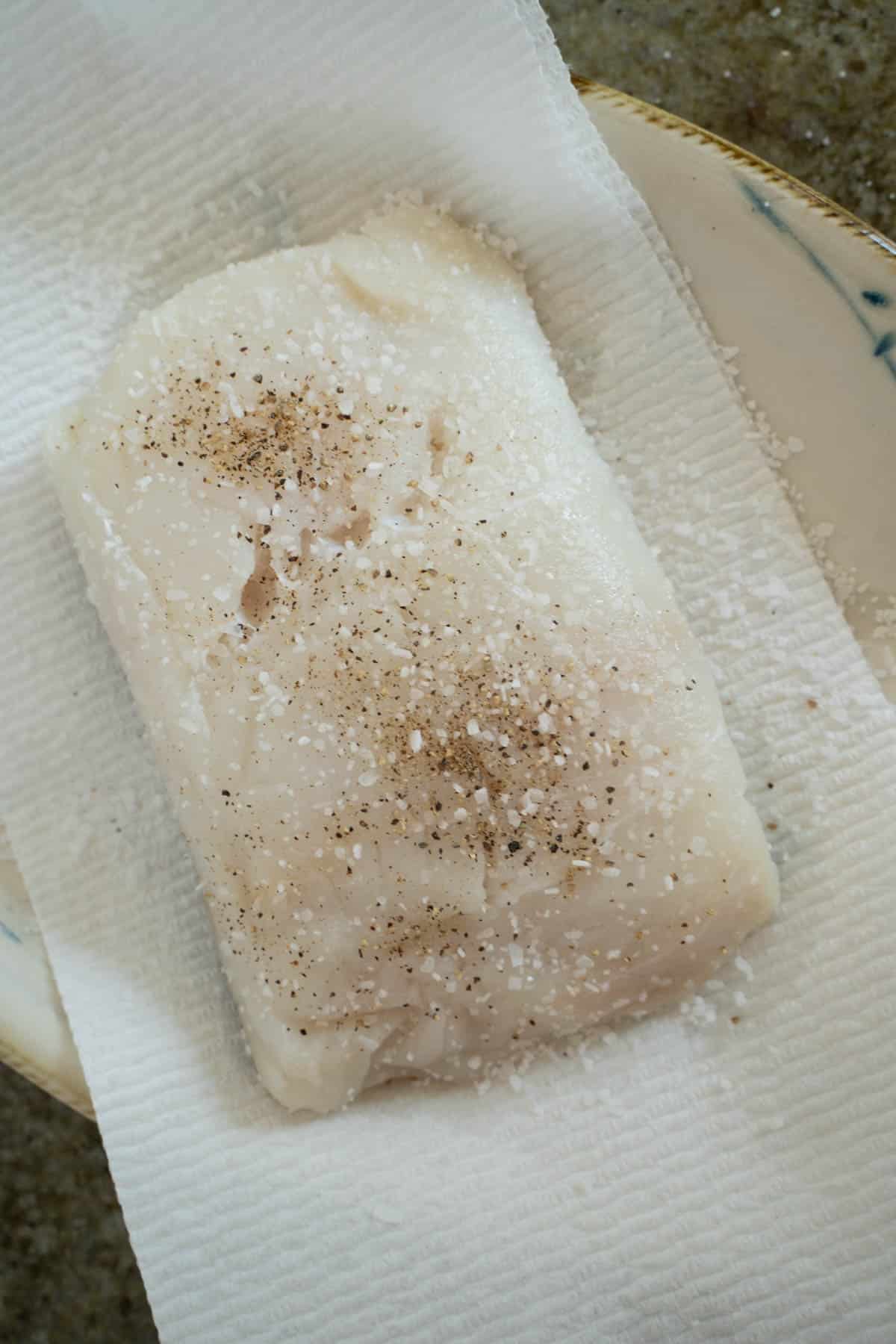 halibut filet sprinkled evenly on all sides with salt mixture on a paper towel