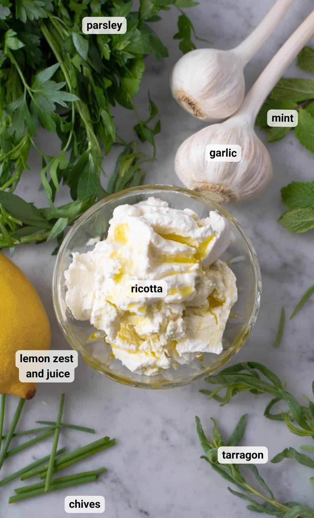 ingredients and herbs for ricotta appetizer on marble counter