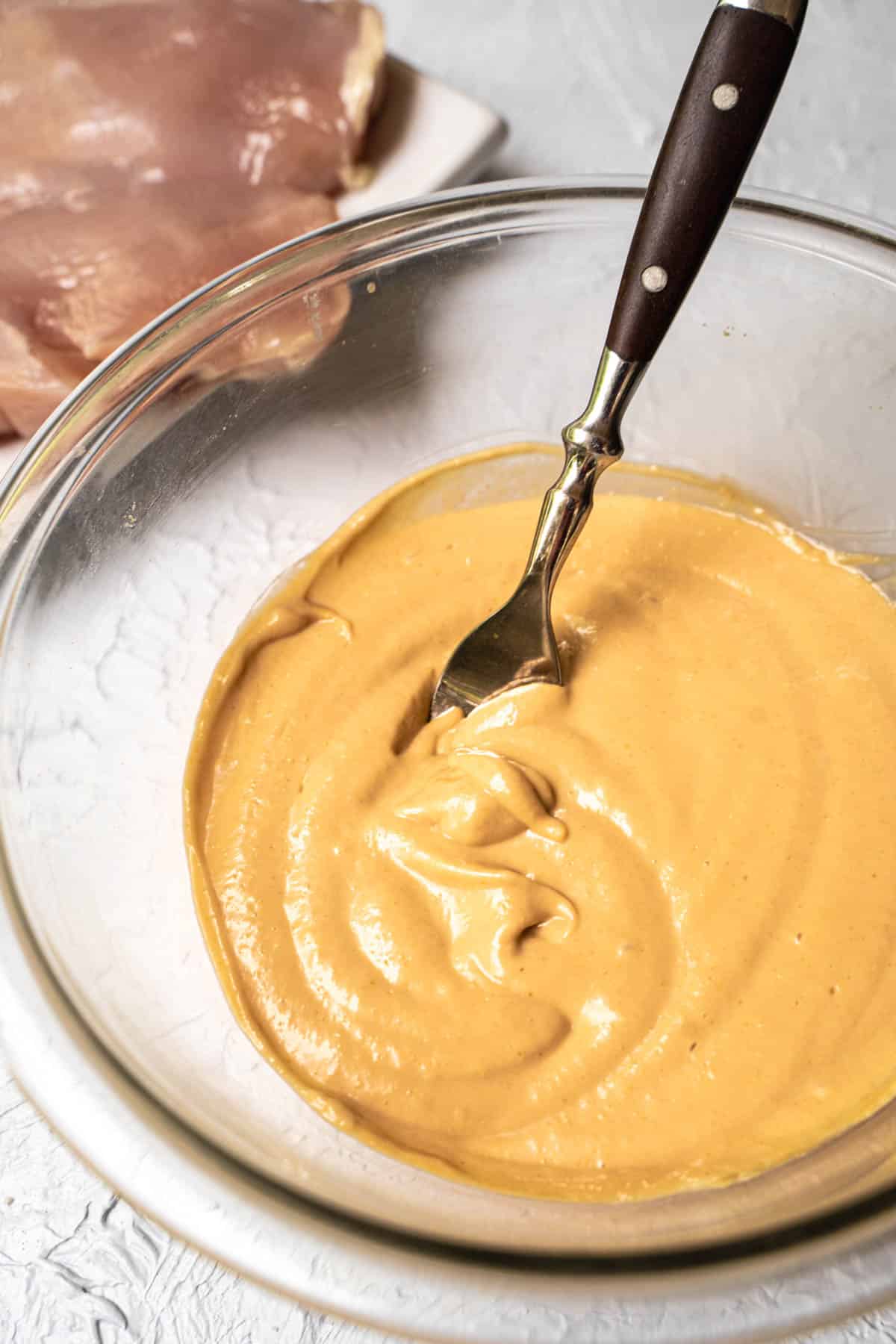 mayo marinade ingredients whisked together in a clear bowl with fork