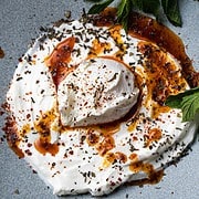 poached egg on a bed of yogurt drizzled with spiced butter
