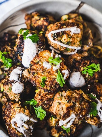 Turkey Zucchini Meatballs for two in a stone bowl drizzled with sour cream sumac sauce and sprinkled with cilantro
