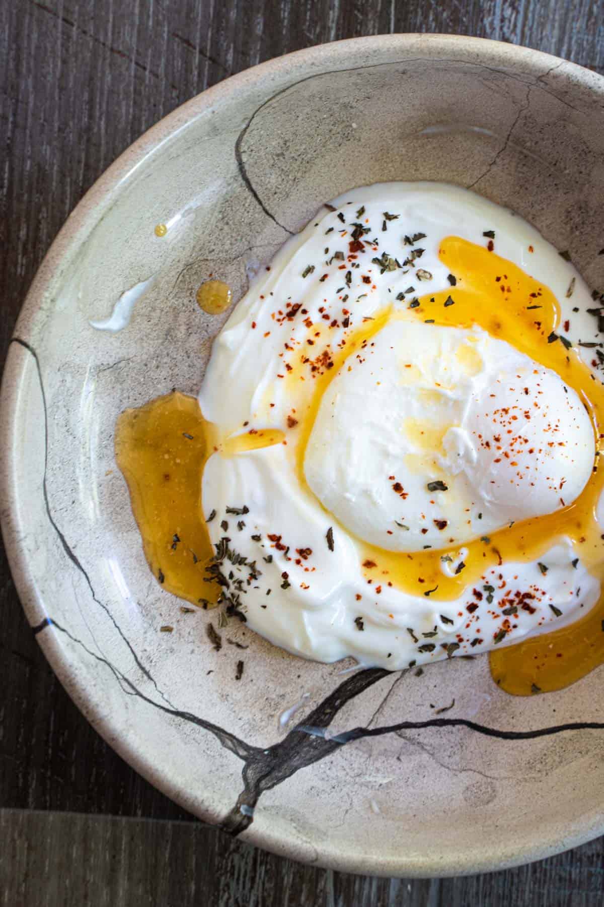 poached egg on a bed of yogurt drizzled with spiced butter