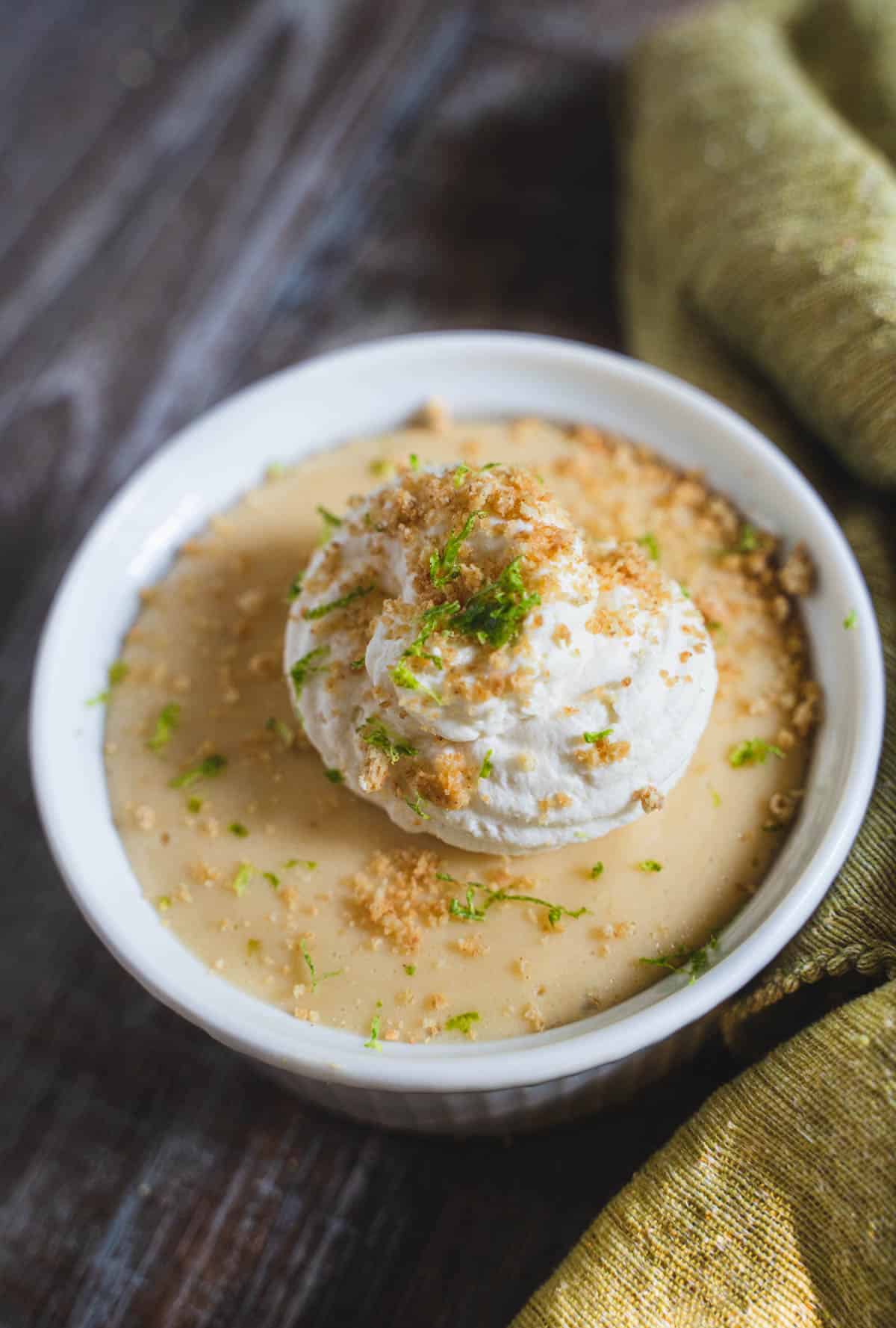 Key Lime Pie filling in a ramekin sprinkled with graham cracker topping and whipped cream