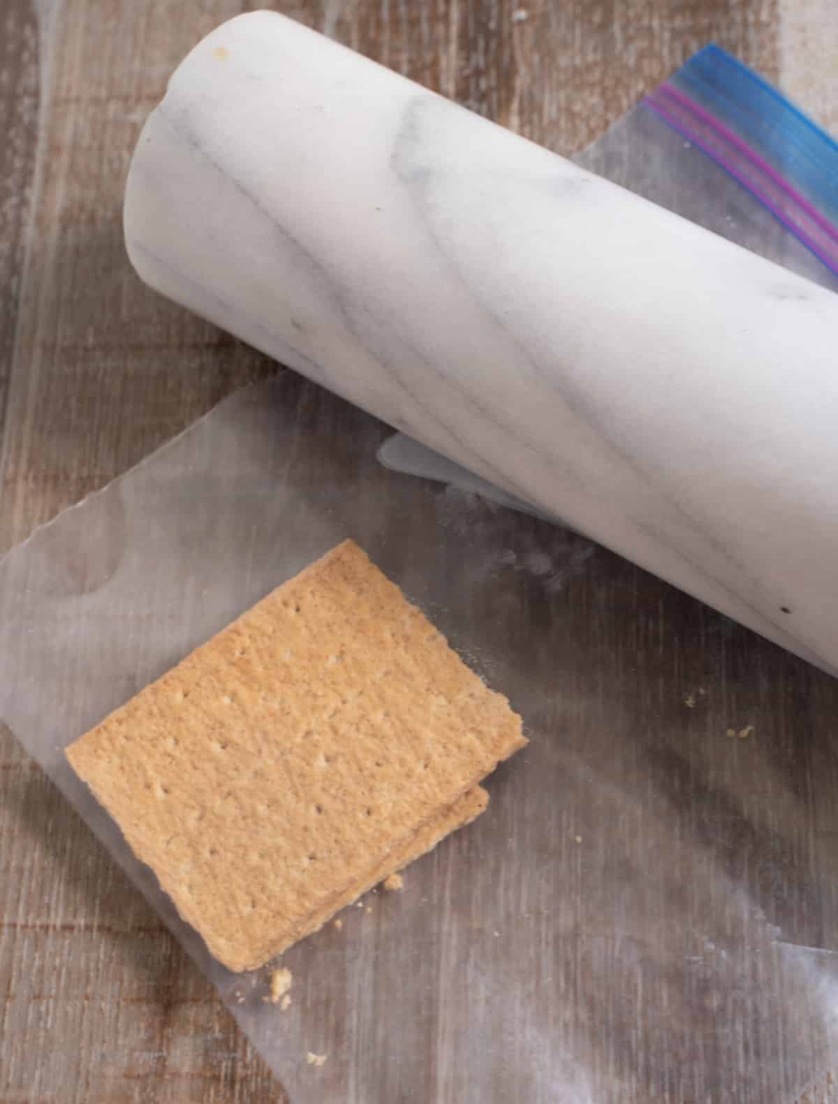 graham cracker in resealable plastic bag next to rolling pin