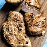 grilled mayo marinated chicken breasts on wooden cutting board