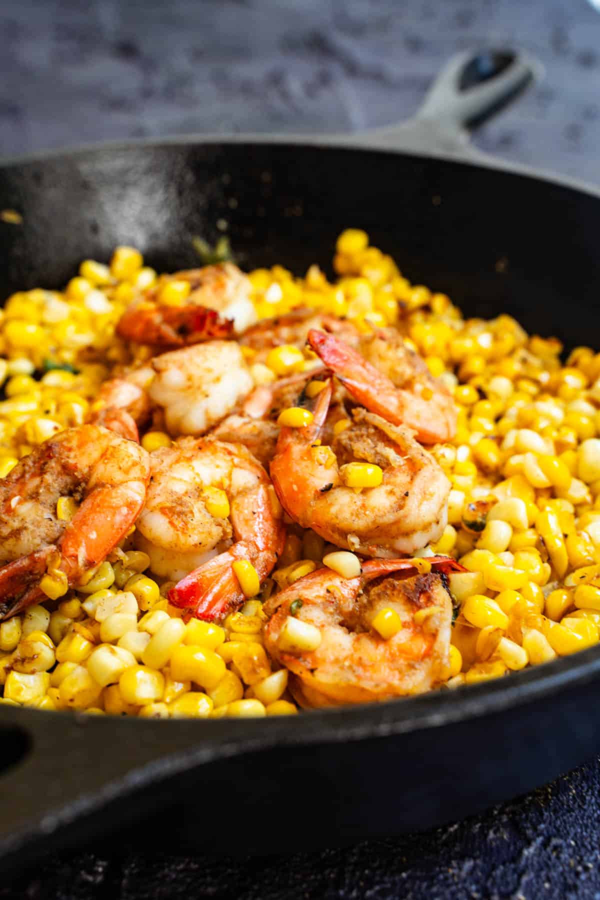 shrimp cooked and corn browned in a cast iron skillet