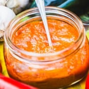 Ajvar dipping sauce in a wide mouth mason jar with a spoon