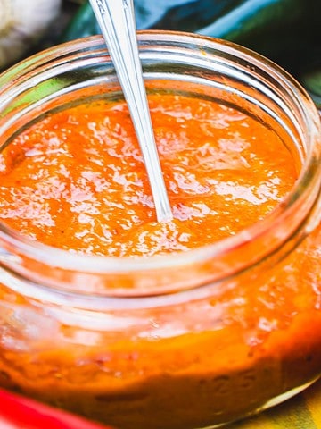 Ajvar dipping sauce in a wide mouth mason jar with a spoon