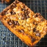 best banana bread with sour cream and brown sugar on a baking rack on a navy blue table