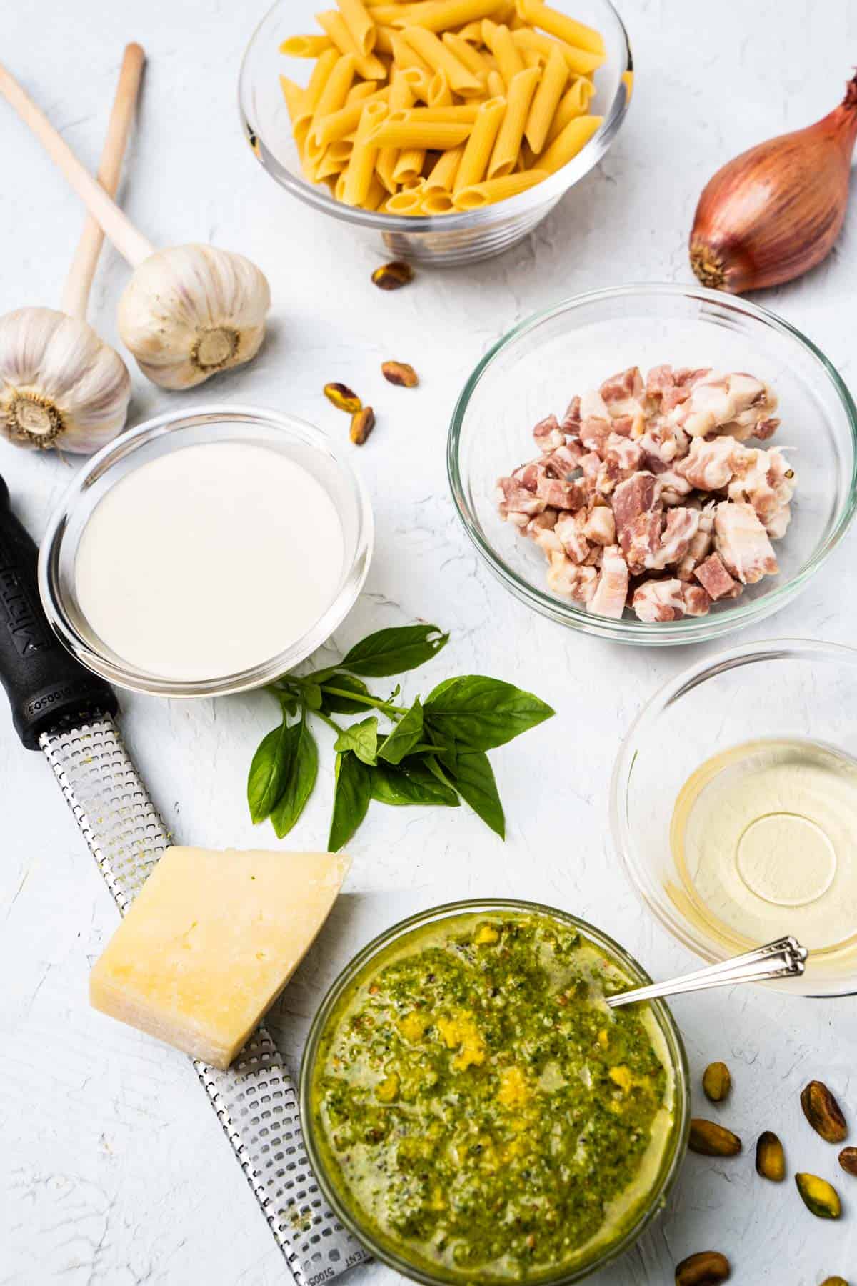 Ingredients for one pot pistachio pesto pasta on a white table