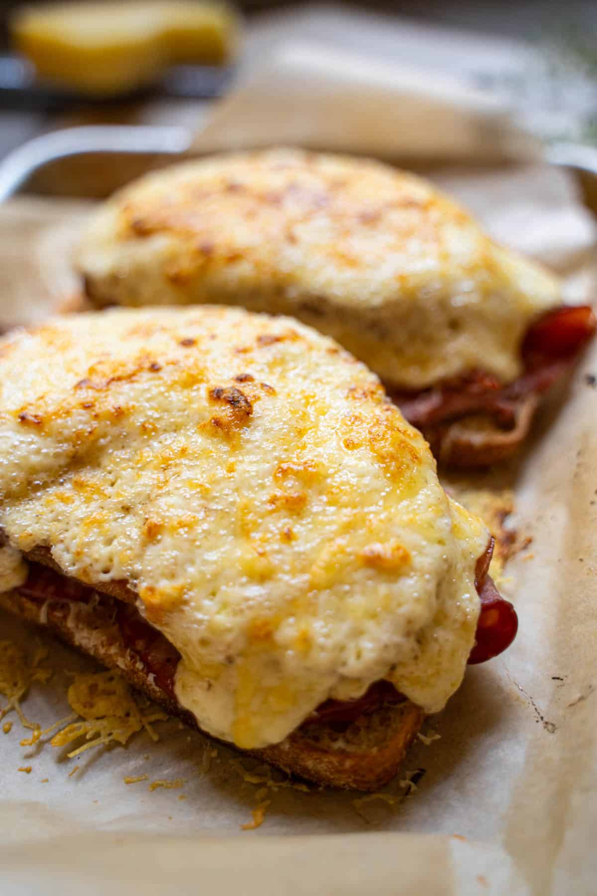 2 Croque Monsieur Sandwiches baked on a baking sheet lined with parchment