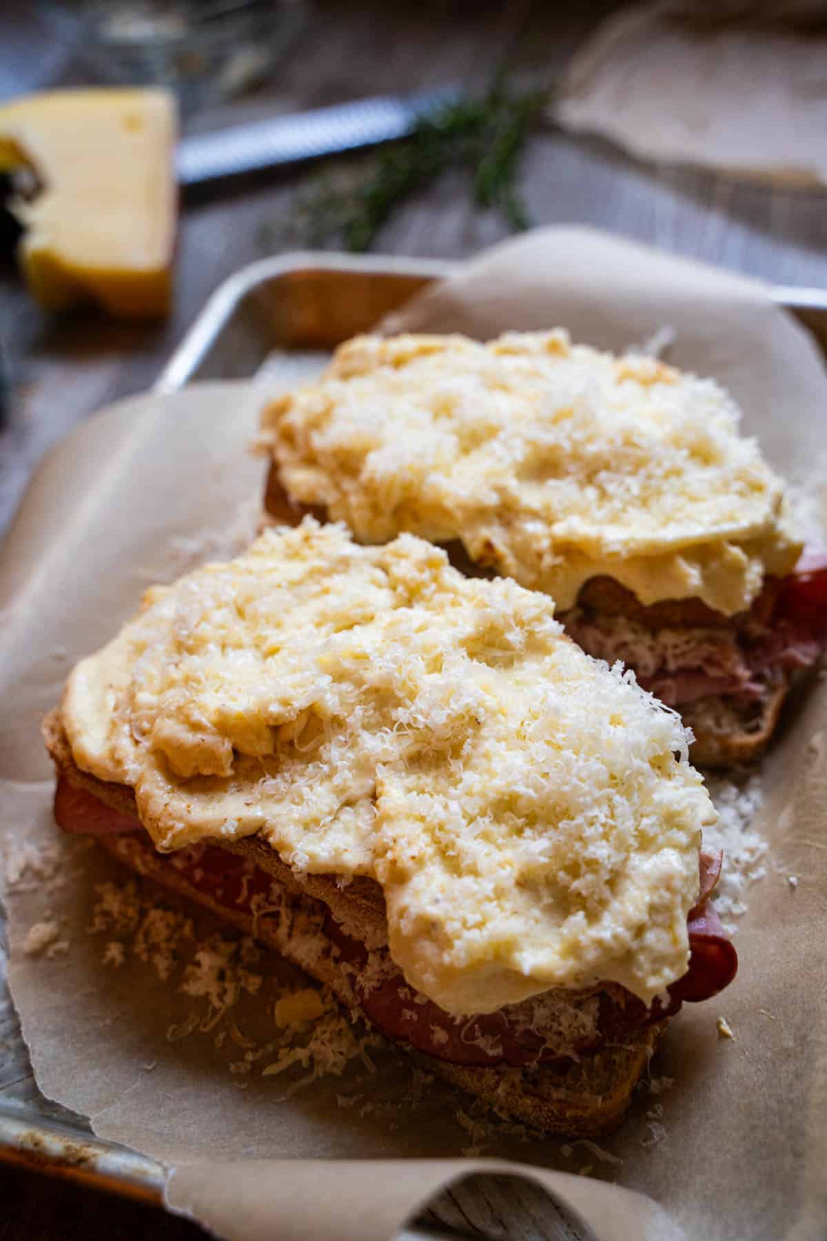 Croque monsieur Sandwiches on a baking sheet lined with parchment ready to bake in oven