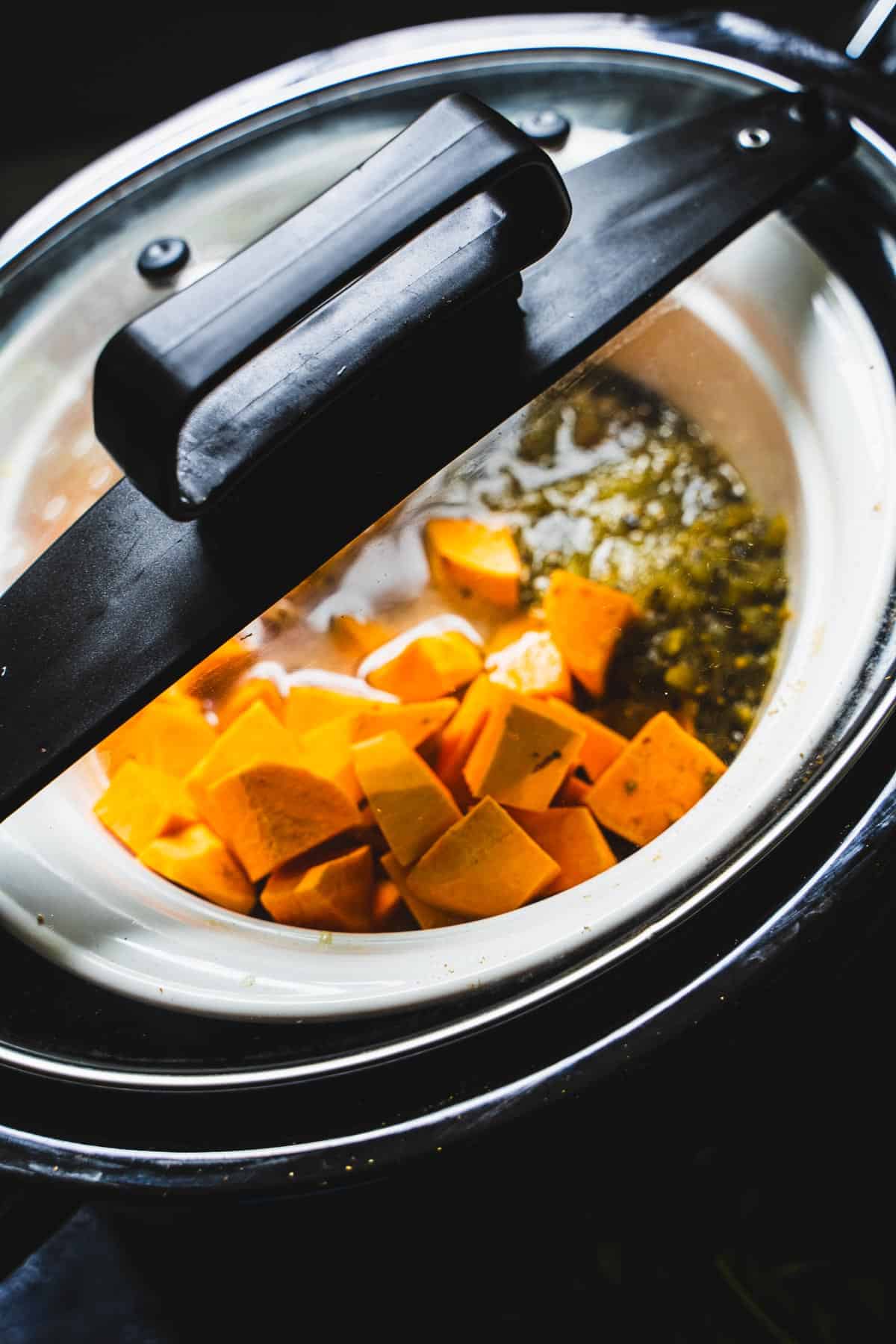 Green chicken chili in covered and cooking in crockpot.