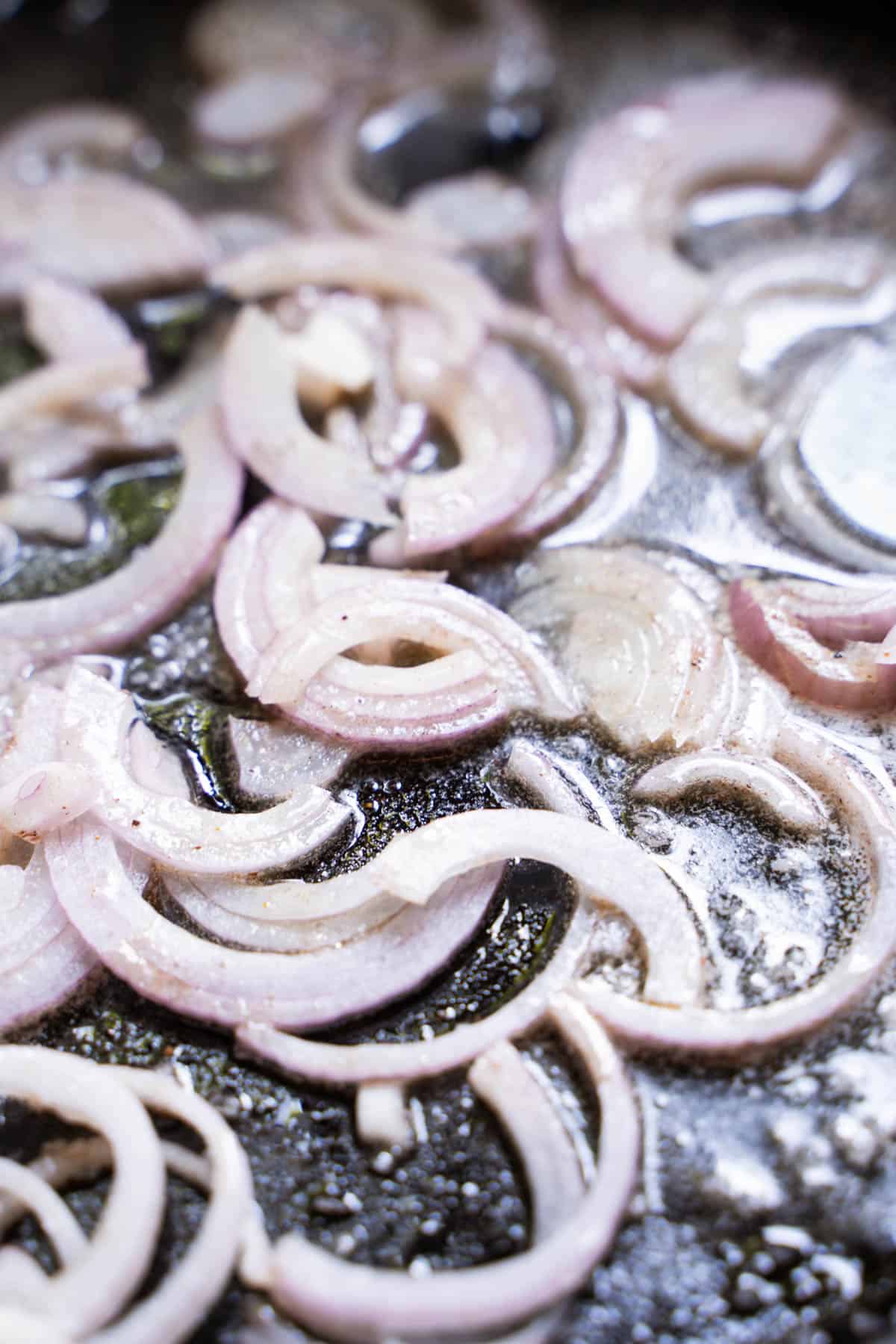 thinly sliced shallots in a fry pan with butter