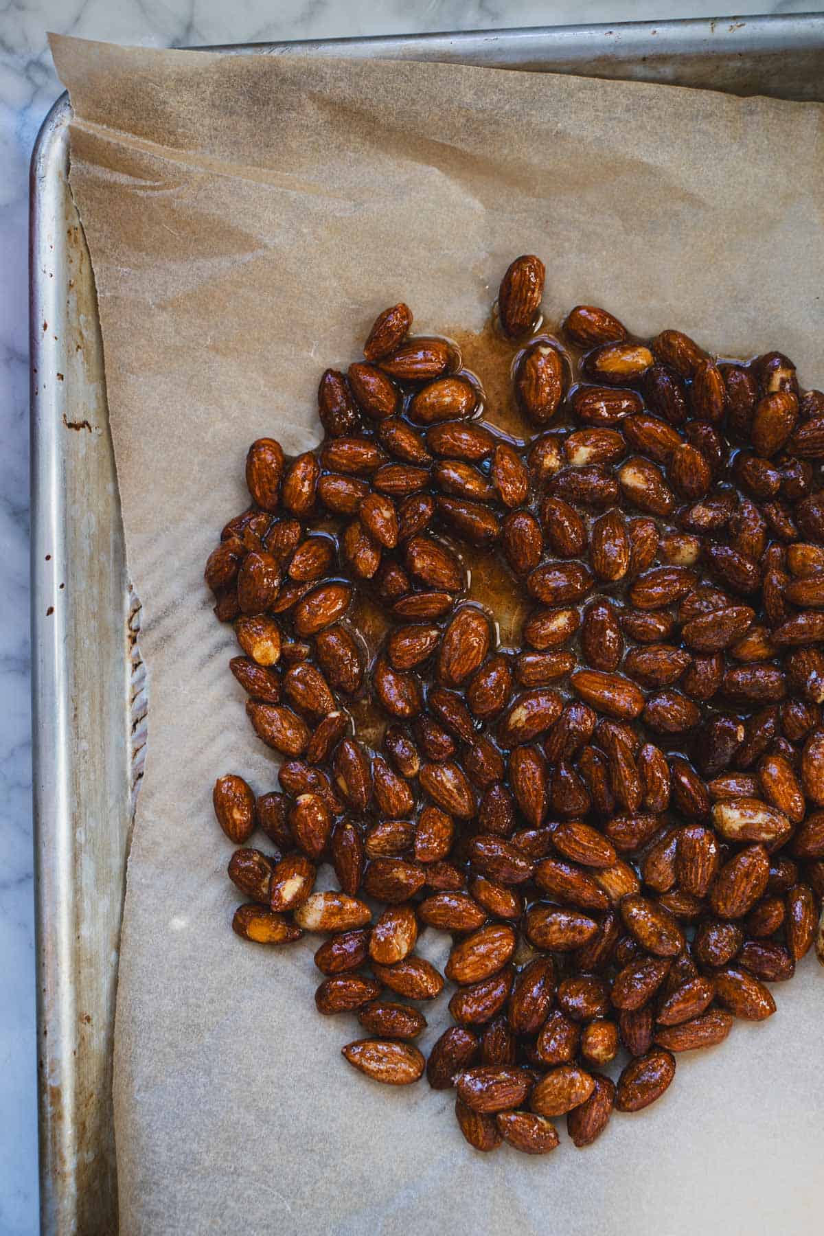 sweet and spicy nuts on a parchment paper lined baking sheet.