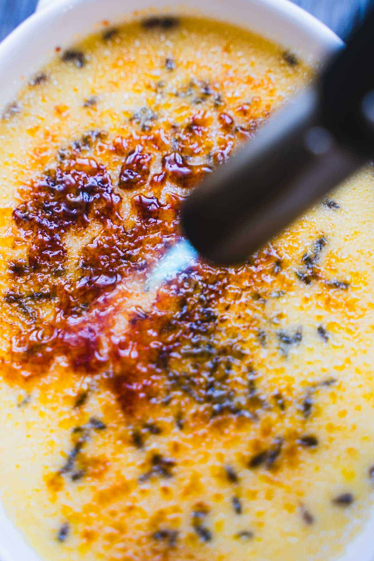 Caramelizing the top of the creme brulee using a kitchen torch.