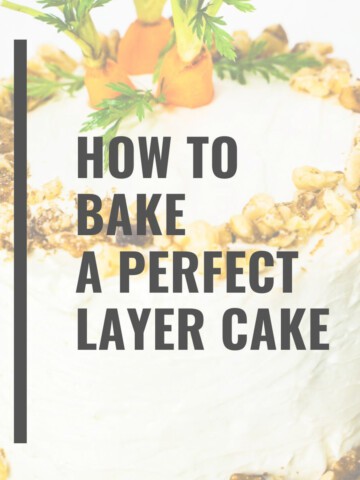 Cream cheese frosted carrot walnut cake with chopped walnuts on edges and fresh carrot tops on top of the small 6-inch 2- layer cake with the words How to Bake a Perfect Layer Cake in text.