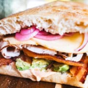 Assembled turkey bacon avocado with cheese, gochujang mayo and arugula sandwich.