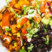 Roasted vegetable fajita bowl topped with avocado, salsa and sour cream.
