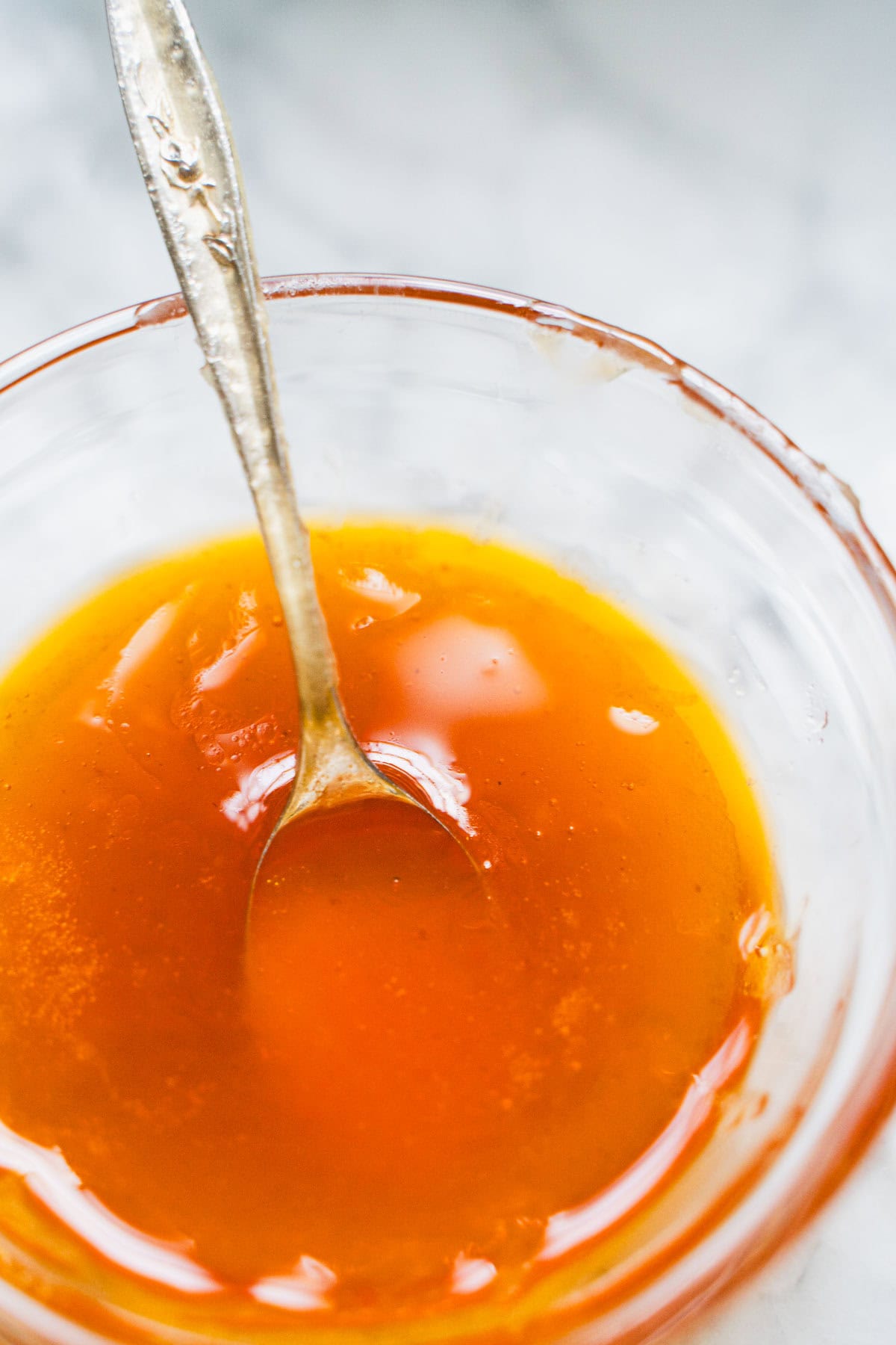 Hot honey sauce in a clear glass bowl for vegetable fajita bowl.